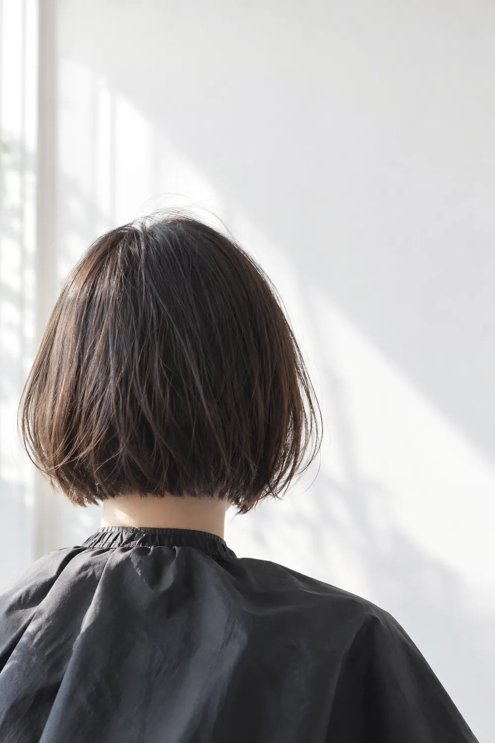 自然な光に照らされた、短いボブの後ろ姿